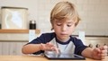 Barn, der interagerer med en tablet, der ligger på bordet