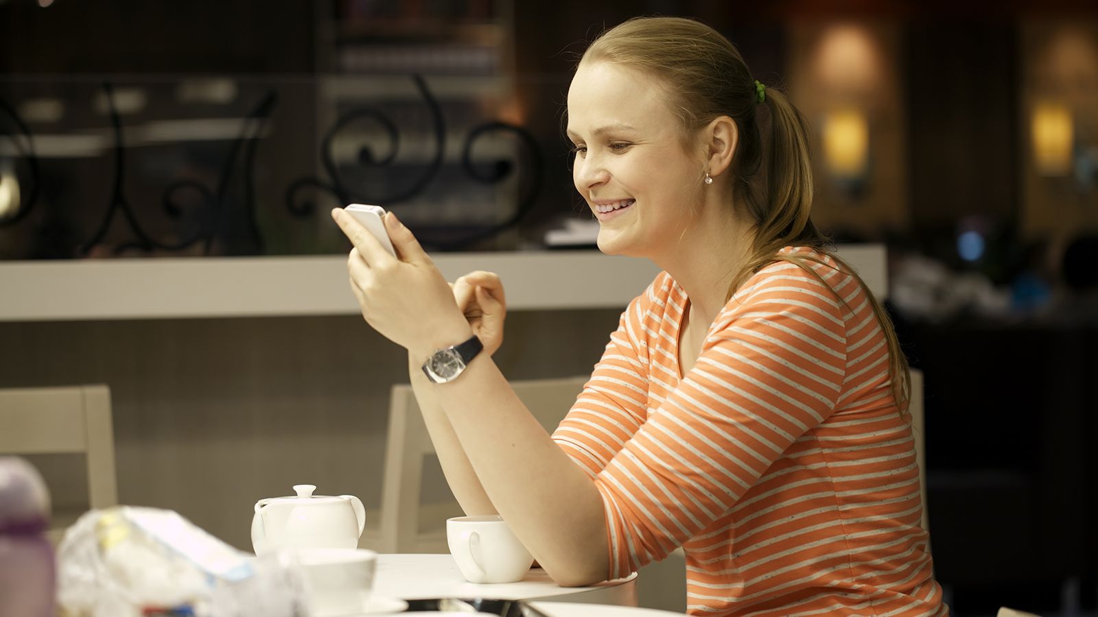 Smilende kvinde med mobiltelefon